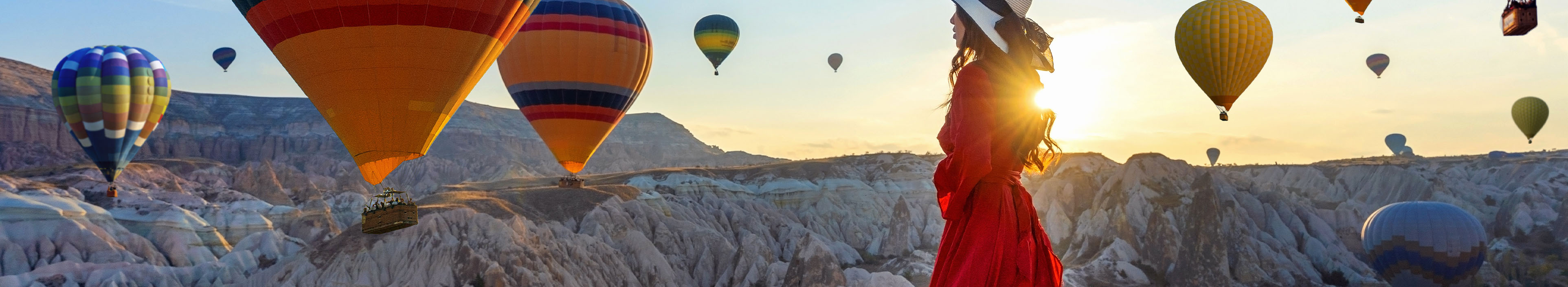 Frau in Kappadokien und drum herum viele Heißluftballons
