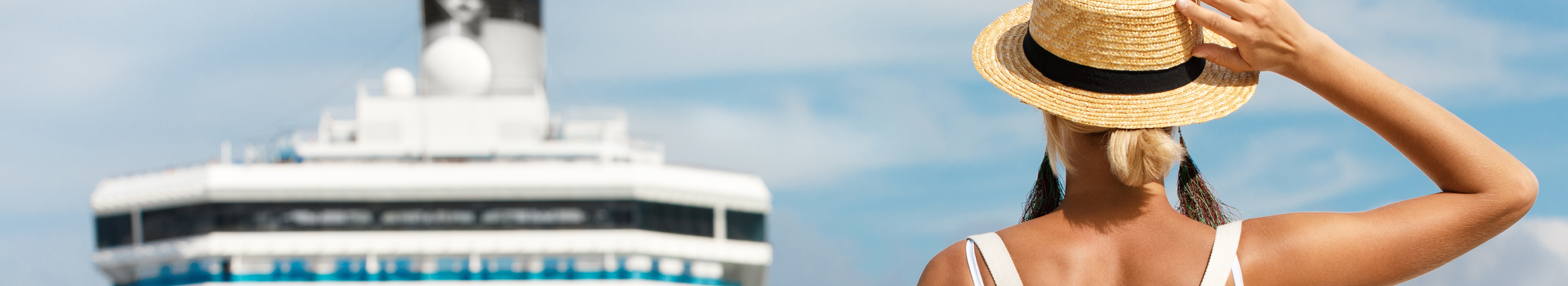 Frau steht vor einem großen Kreuzfahrtschiff